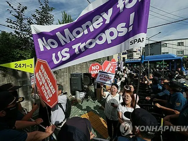 今年７月、ＳＭＡ締結に向けた交渉の中止を求めて集会を開く市民団体＝（聯合ニュース）