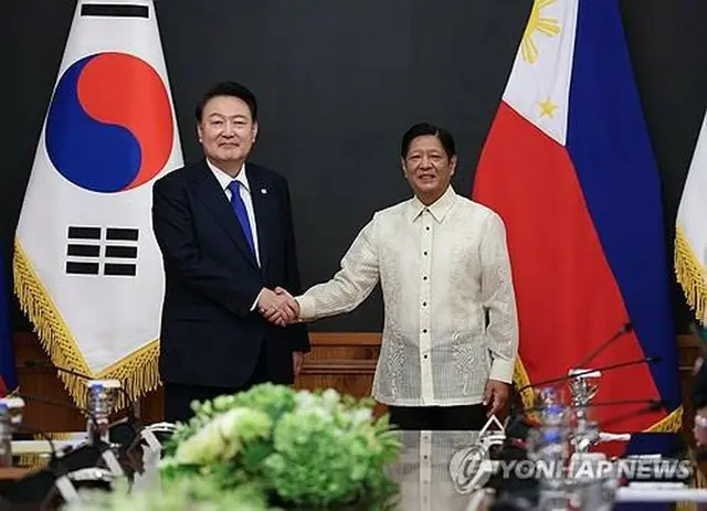 首脳会談で握手を交わす韓国の尹錫悦大統領（左）とフィリピンのマルコス大統領＝７日、マニラ（聯合ニュース）