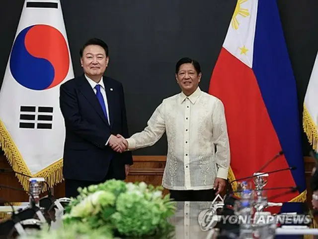 首脳会談で握手を交わす韓国の尹錫悦大統領（左）とフィリピンのマルコス大統領＝７日、マニラ（聯合ニュース）