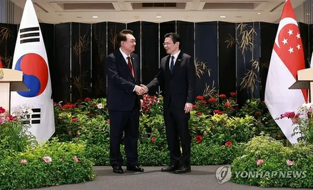 共同記者発表で握手を交わす韓国の尹錫悦大統領（左）とシンガポールのウォン首相＝８日、シンガポール（聯合ニュース）