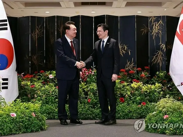 共同記者発表で握手を交わす韓国の尹錫悦大統領（左）とシンガポールのウォン首相＝８日、シンガポール（聯合ニュース）