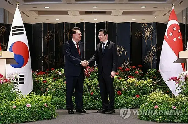 共同記者発表で握手を交わす韓国の尹錫悦大統領（左）とシンガポールのウォン首相＝８日、シンガポール（聯合ニュース）