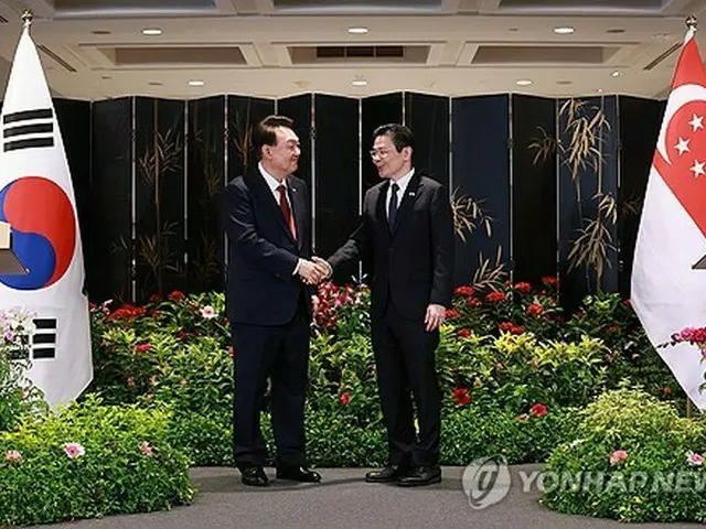 共同記者発表で握手を交わす韓国の尹錫悦大統領（左）とシンガポールのウォン首相＝８日、シンガポール（聯合ニュース）