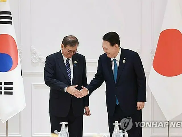 首脳会談で握手を交わす韓国の尹大統領（右）と日本の石破首相＝１０日、エンチャン（聯合ニュース）