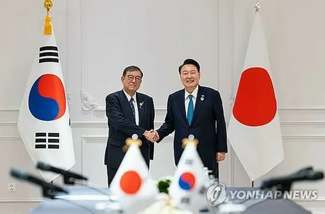 首脳会談で握手を交わす韓国の尹大統領（右）と日本の石破首相＝１０日、ビエンチャン（聯合ニュース）