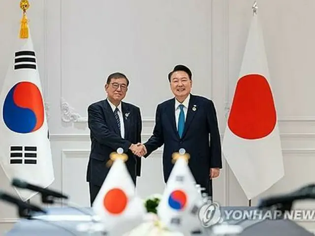 首脳会談で握手を交わす韓国の尹大統領（右）と日本の石破首相＝１０日、ビエンチャン（聯合ニュース）