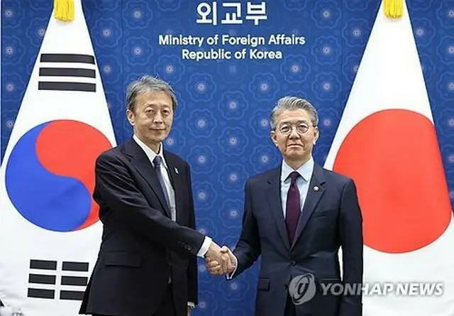 会談前、握手を交わす韓国外交部の金烘均第１次官（右）と日本の岡野正敬外務事務次官＝１７日、ソウル（聯合ニュース）