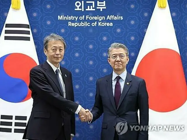 会談前、握手を交わす韓国外交部の金烘均第１次官（右）と日本の岡野正敬外務事務次官＝１７日、ソウル（聯合ニュース）