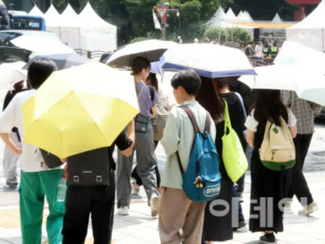 韓国全土で連日猛暑が続いた8月、市民が日傘をさして歩く様子