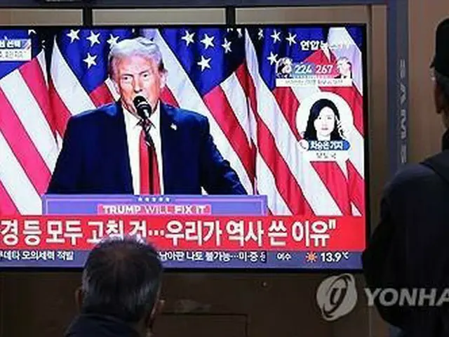 ソウル駅に設置されたテレビで米大統領選のニュースを見る人たち＝６日、ソウル（聯合ニュース）