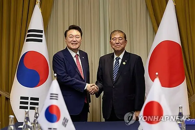 握手を交わす韓国の尹錫悦大統領（左）と日本の石破茂首相＝１６日、リマ（聯合ニュース）