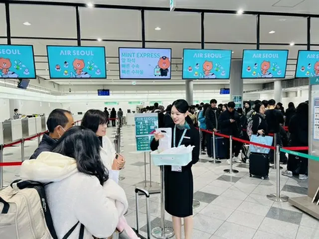 高松空港で乗客に記念品を手渡すエアソウルの職員（同社提供）＝（聯合ニュース）≪転載・転用禁止≫