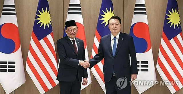 首脳会談前、握手を交わす韓国の尹大統領（右）とマレーシアのアンワル首相＝２５日、ソウル（聯合ニュース）