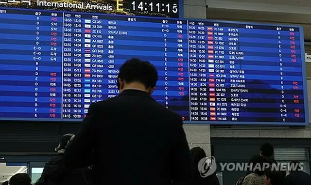 赤い文字で「遅延」と表示された仁川空港の電光掲示板＝２７日、仁川（聯合ニュース）