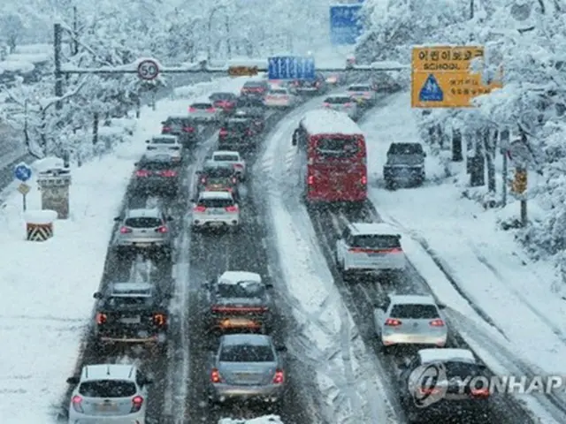 雪道を徐行する車＝２８日、水原（聯合ニュース）