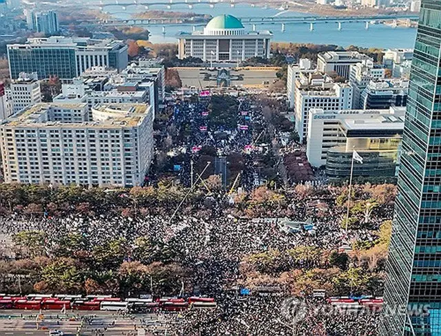 国会前に集まった市民たち＝１４日、ソウル（聯合ニュース）