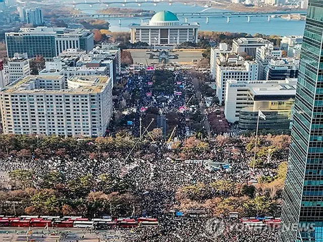 国会前に集まった市民たち＝１４日、ソウル（聯合ニュース）