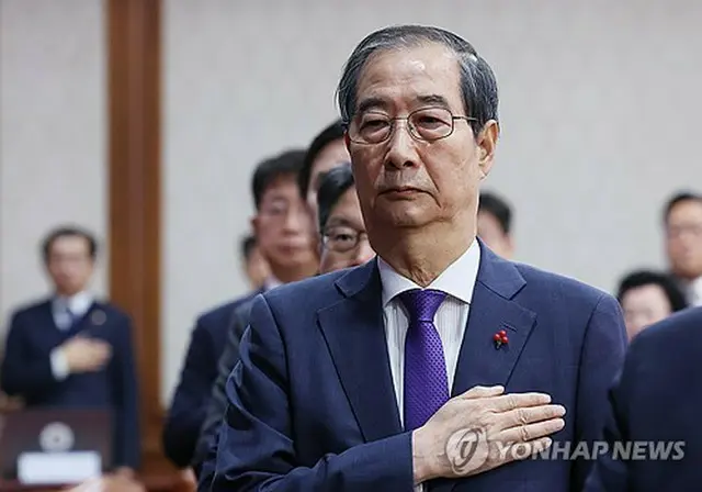 韓国の韓悳洙（ハン・ドクス）大統領権限代行首相が１７日、政府ソウル庁舎で閣議を主宰した。国旗に敬礼する韓氏＝（聯合ニュース）