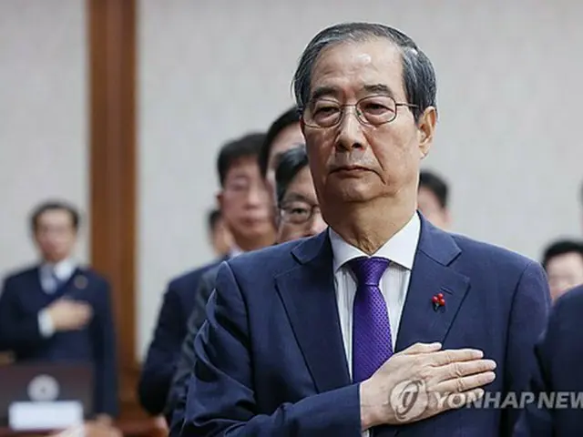 韓国の韓悳洙（ハン・ドクス）大統領権限代行首相が１７日、政府ソウル庁舎で閣議を主宰した。国旗に敬礼する韓氏＝（聯合ニュース）