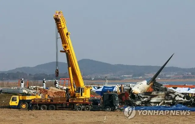 務安国際空港の事故現場で作業を行うクレーン＝２９日、務安（聯合ニュース）