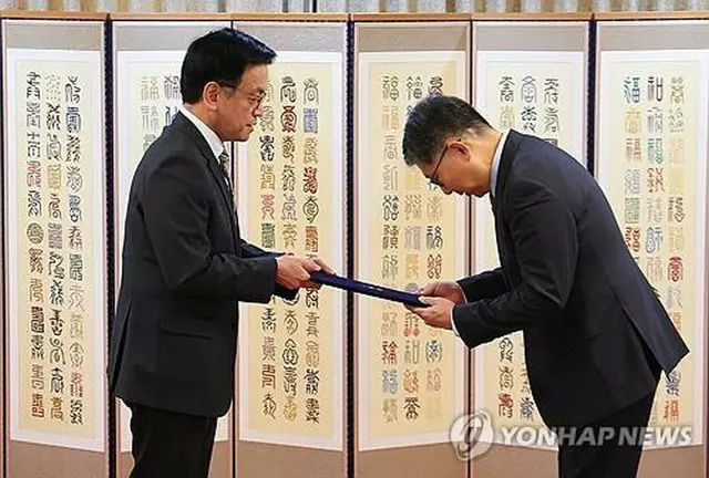 初代キューバ大使に任命された李昊烈（イ・ホヨル）氏（右）に任命状を授与する崔氏＝３１日、ソウル（聯合ニュース）