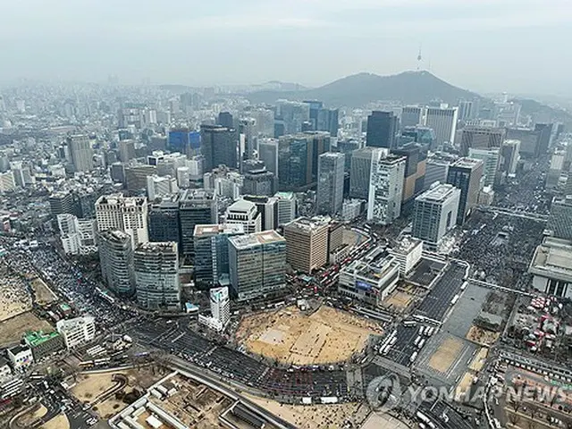 ソウル都心で開かれた尹大統領の罷免を求める集会（左側）と尹大統領の弾劾に反対する集会（右上）＝１日、ソウル（聯合ニュース）